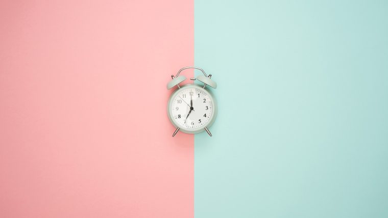 大赛 App 主界面在深墨绿色桌面上的居中展示，屏幕内是金棕色赛程卡片与倒计时条，光线偏暖，整体呈复古怀旧质感